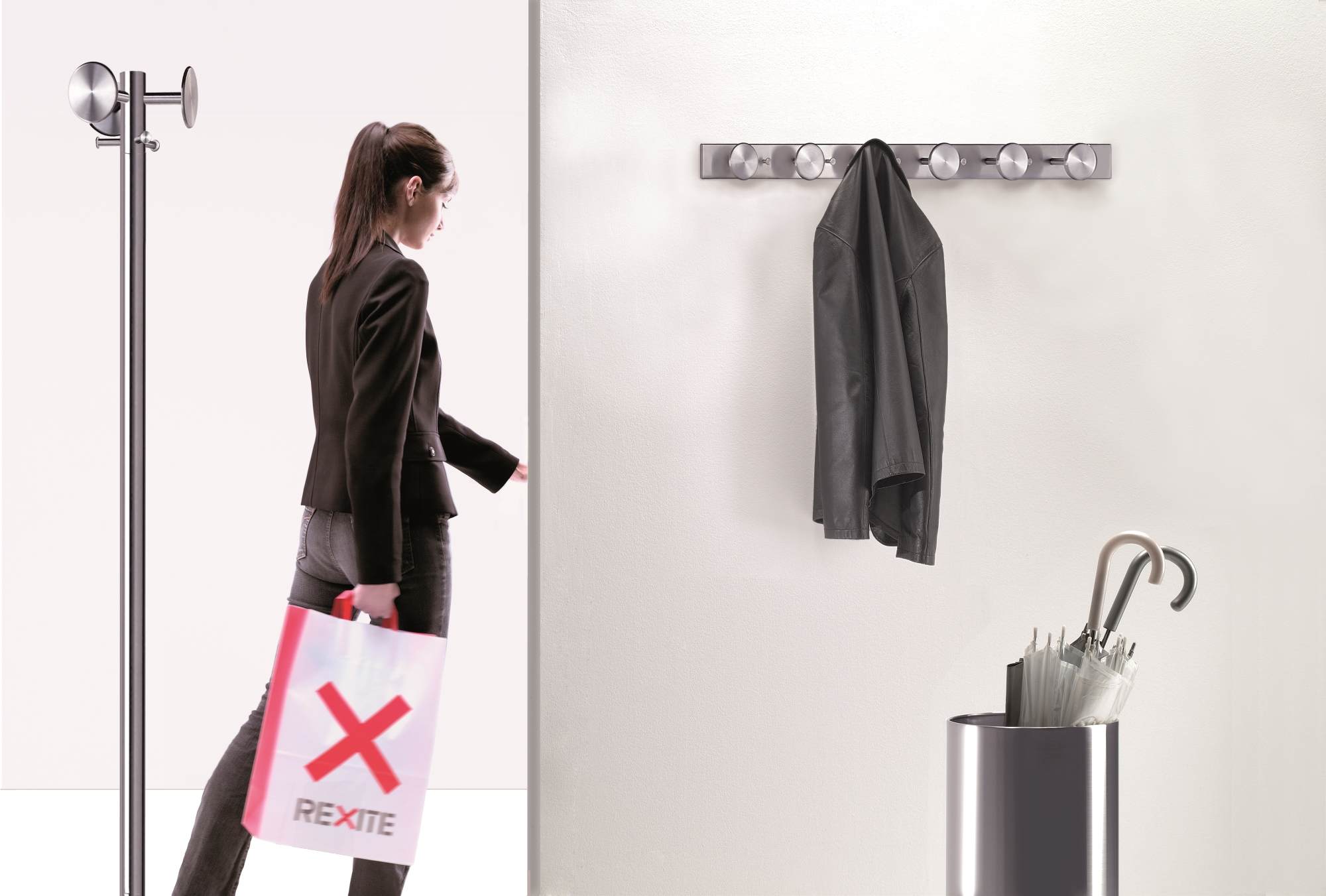 Nox Papierkorb/Schirmständer von Rexite: Silberner, hoher Behälter mit Regenschirmen, daneben eine Frau mit Rexite-Tasche.
