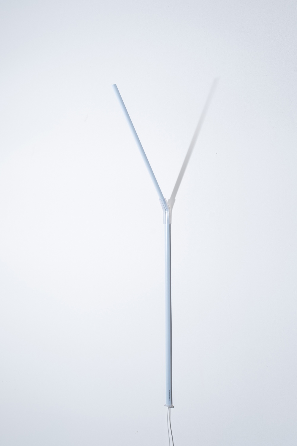 Weiße Ingo Maurer Wandleuchte "Measure Light" mit Y-förmigem Leuchtenarm und minimalistischem Design.