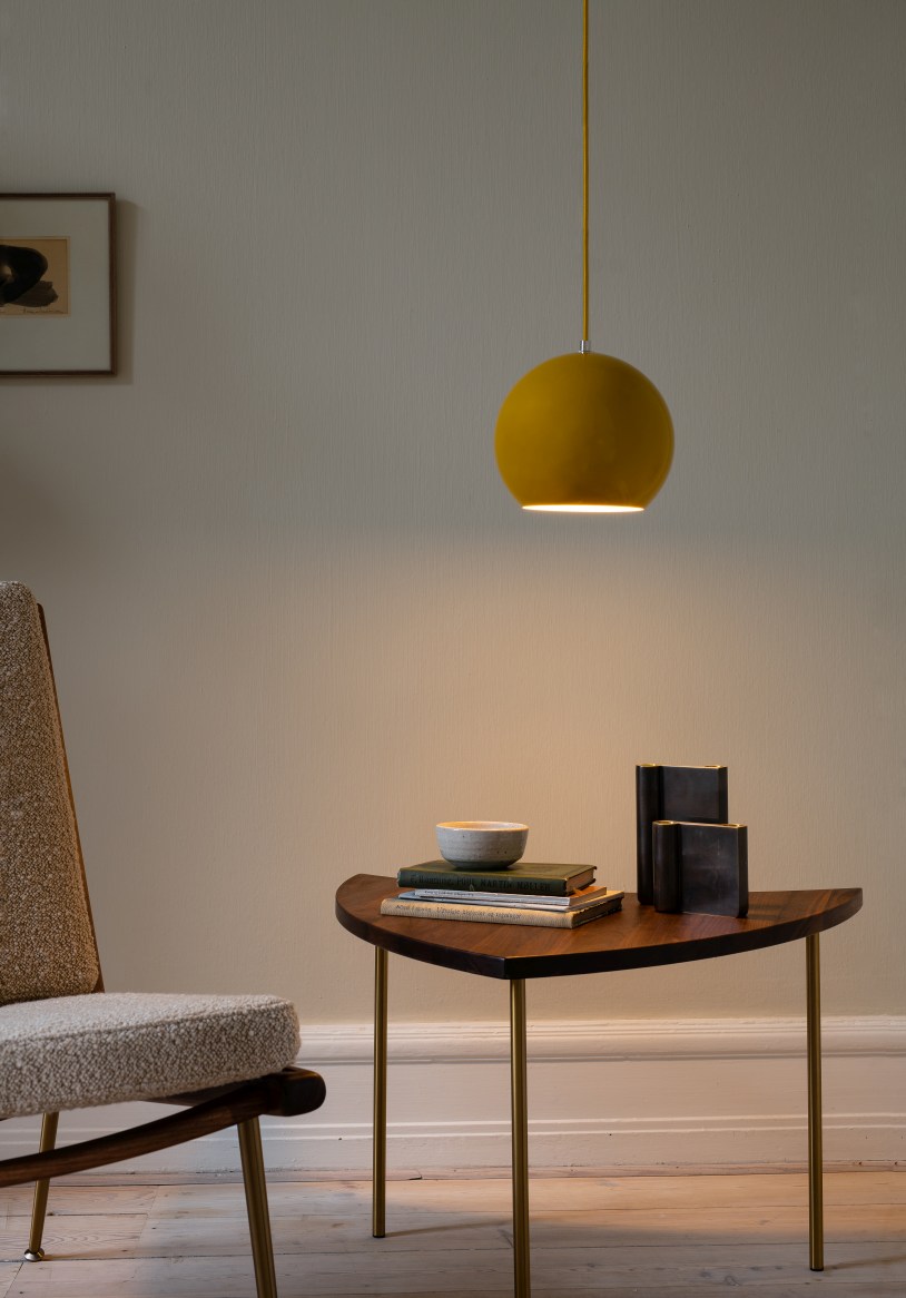 Detailaufnahme: Boomerang Lounge Chair Sessel mit Beistelltisch und gelber Pendelleuchte. Designmöbel für Wohnzimmer.