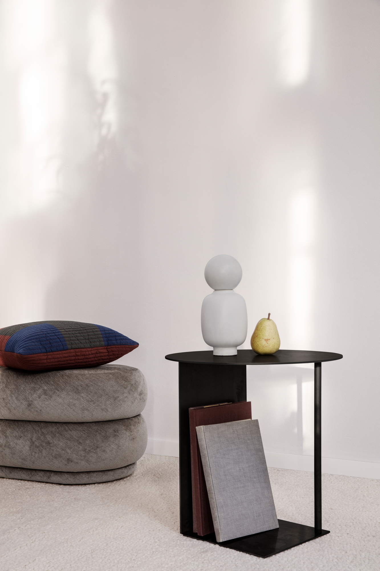 Ferm Living Pouf Hocker aus Samt in Grau mit Kissen und Beistelltisch.