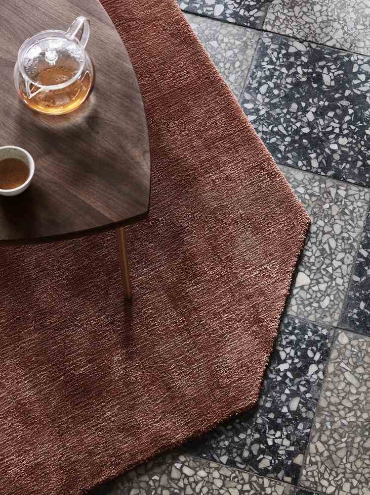 Nahaufnahme des AndTradition Pinwheel Beistelltischs mit Teekanne und Tasse auf einem braunen Teppich.