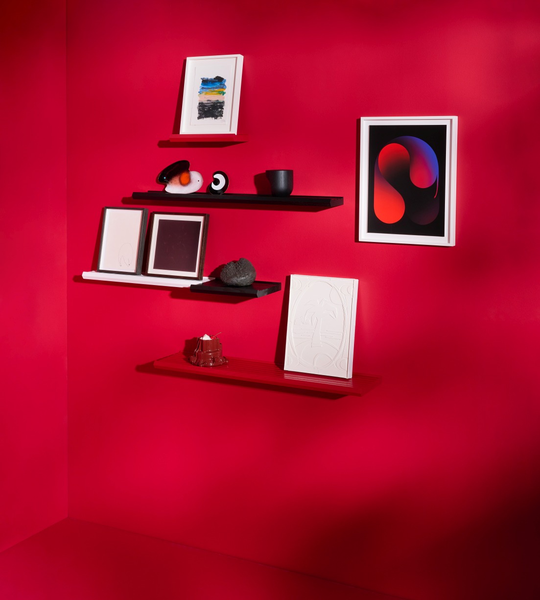 Wand mit mehreren Scena Bilderleisten von Schönbuch in Rot, Schwarz und Weiß mit Dekoration.