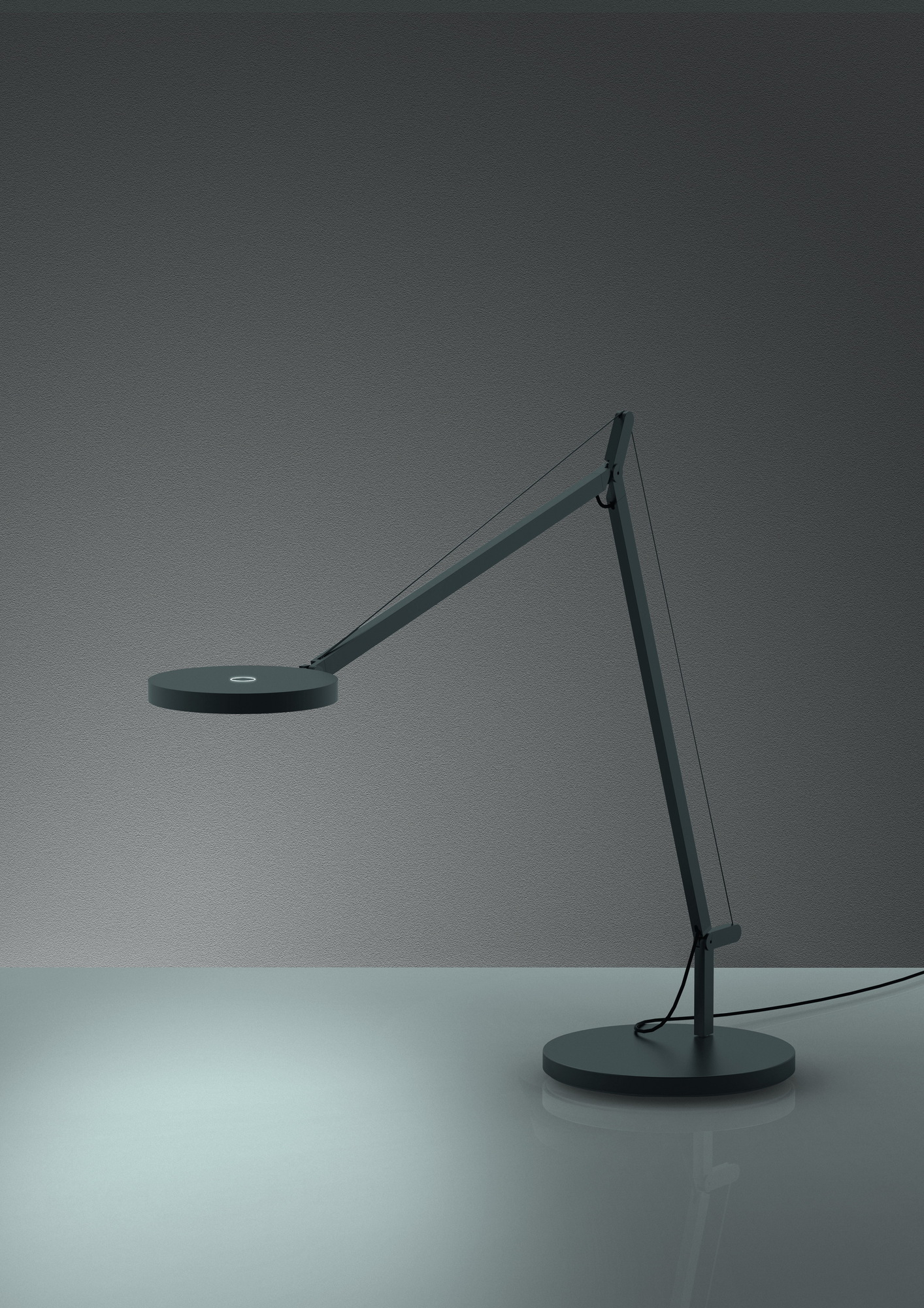 Dunkelgraue Demetra Tischleuchte von Artemide mit verstellbarem Arm und rundem Leuchtenkopf.