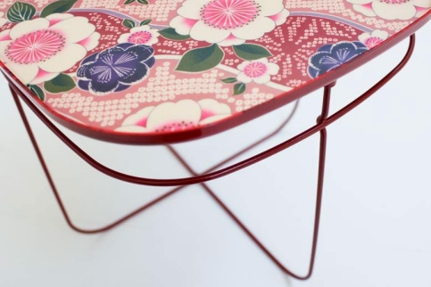 Detailaufnahme des Ukiyo Tisch von Moroso mit floralem Muster und rotem Metallgestell.