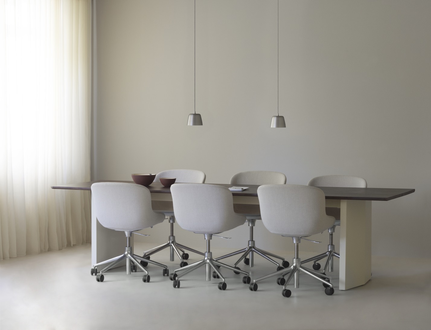 Normann Copenhagen Panel Tisch / Esstisch mit Stühlen und Pendelleuchten in einem hellen Raum.