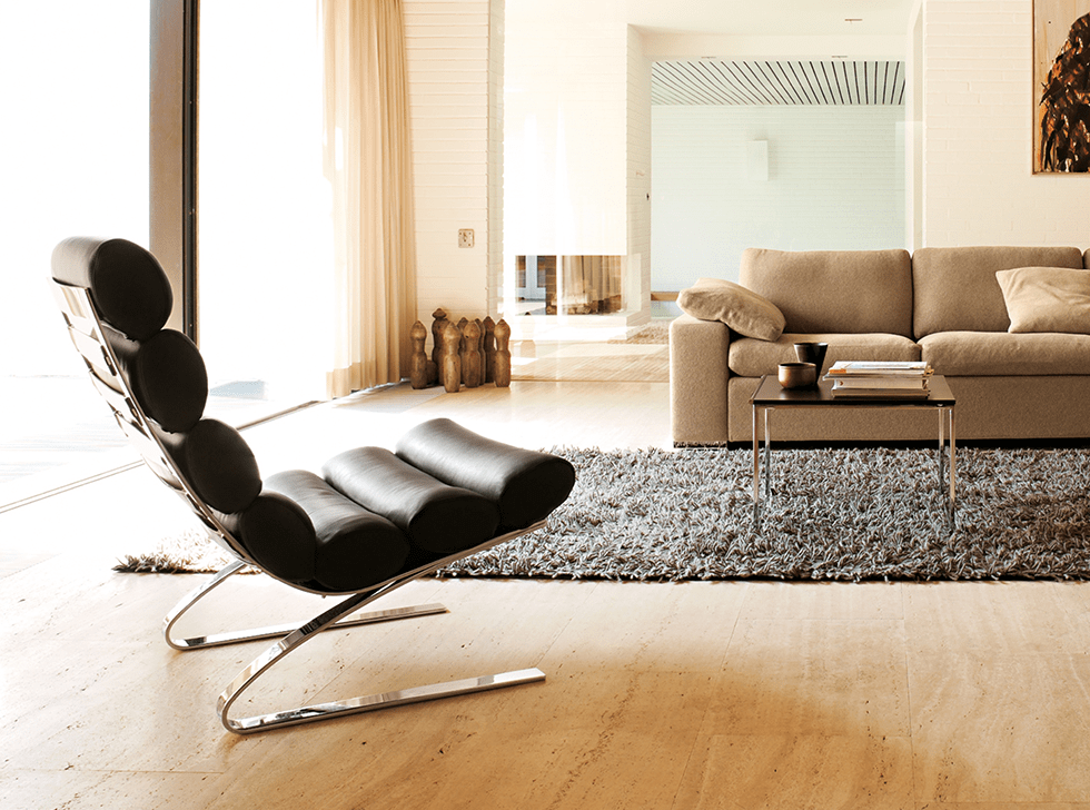 Schwarzer Cor Sinus Sessel ohne Armlehnen mit Chromgestell in modernem Wohnzimmer. Design Sessel für stilvolles Wohnen.