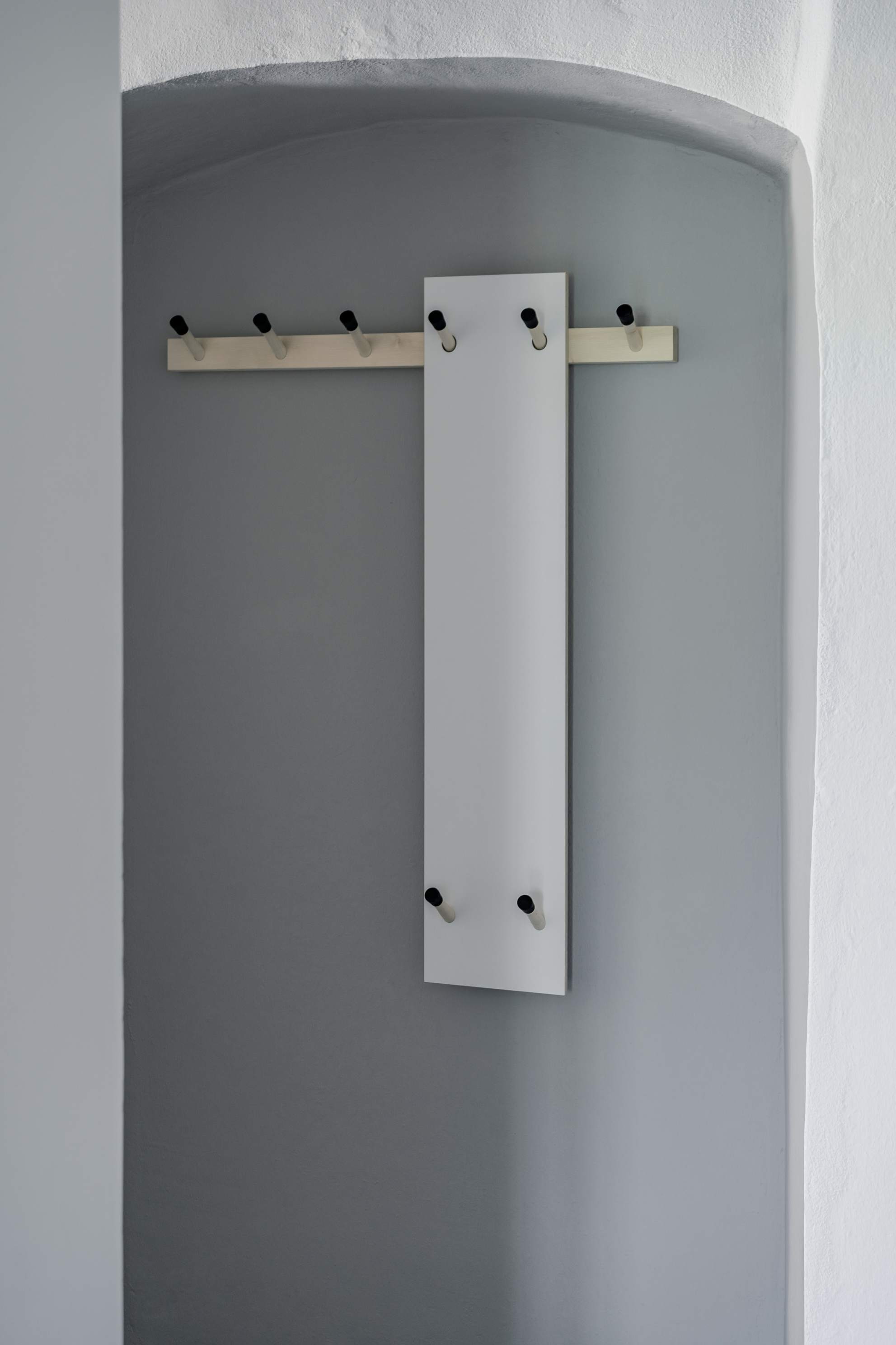 Rechenbeispiel Hakenleiste von Nils Holger Moormann: Moderne Garderobe mit Haken aus Holz und weißem Paneel.