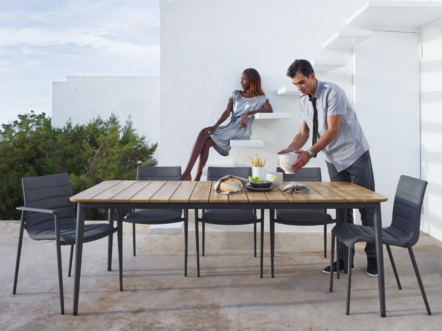 Core Outdoor Stuhl von Cane-Line am Esstisch im Freien mit Personen. Gartenmöbel.