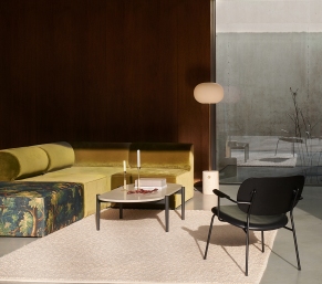 JWDA Stehleuchte von Audo mit Travertin-Fuß und Messinggestell im modernen Wohnzimmer.