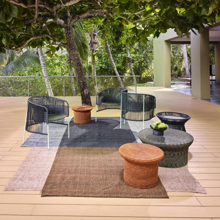 Nobsa Teppich: Großer, mehrfarbiger Outdoor-Teppich mit Gartenmöbeln auf einer Holzterrasse.