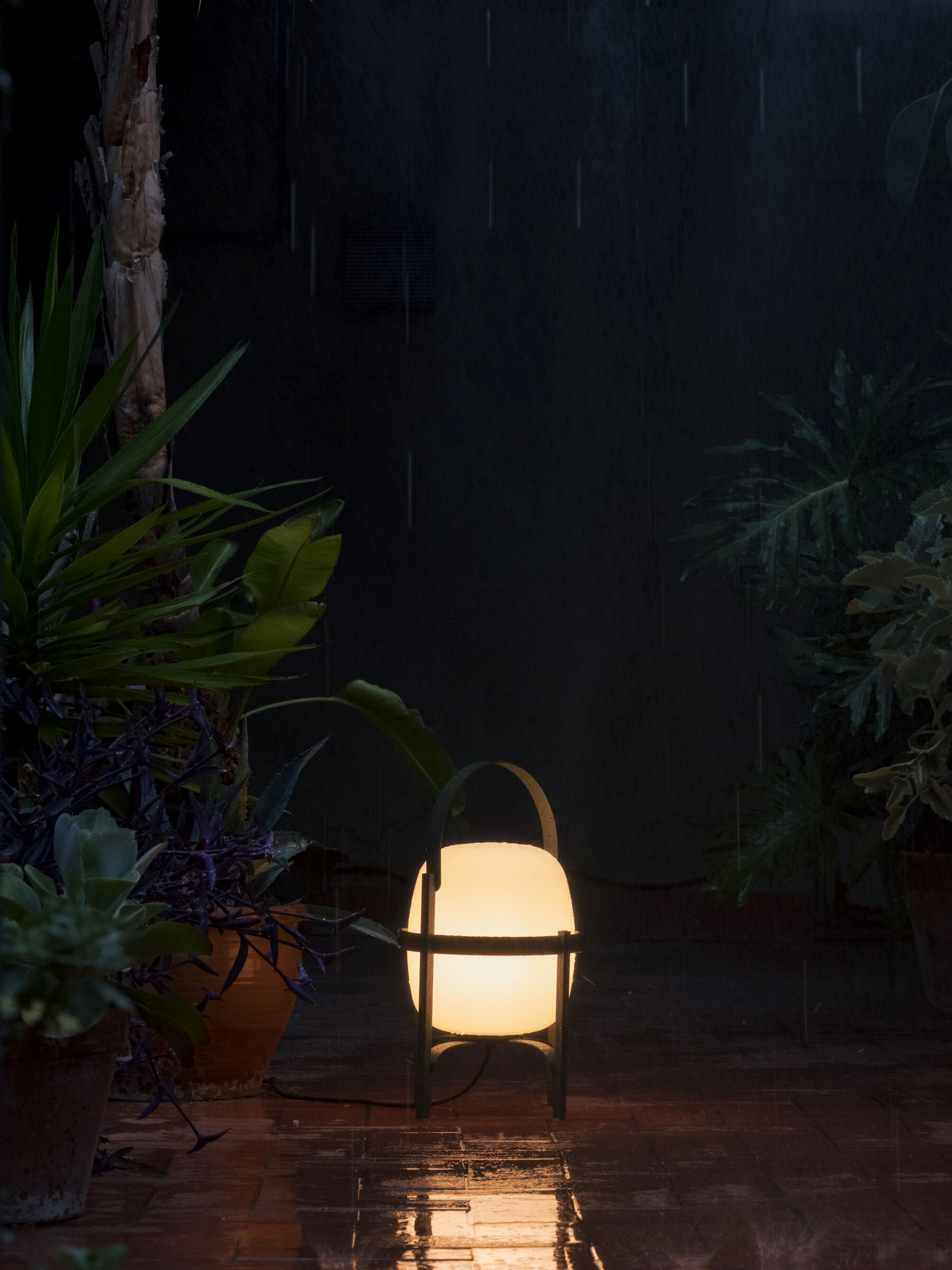 Cesta Outdoor Tischleuchte von Santa & Cole in English Green im Regen. Gartenleuchte.