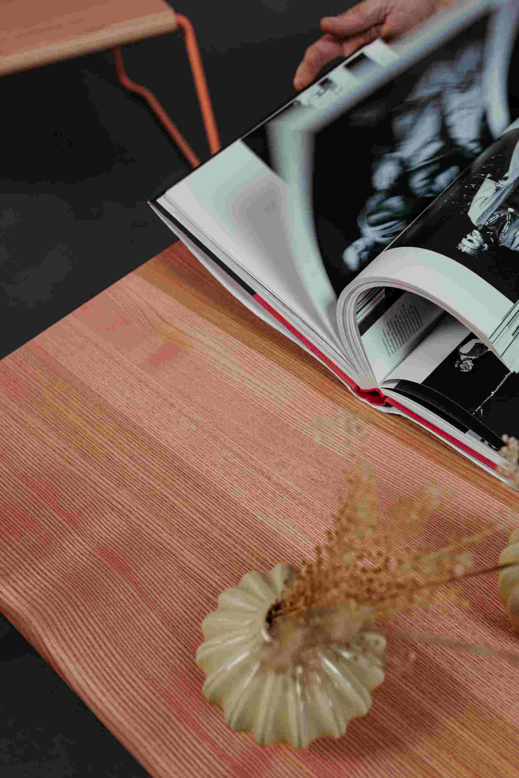 D:009 Coffeetable Kohleschwarz Fuchs & Habicht mit Buch, Vase und Trockenblumen auf der Tischplatte.