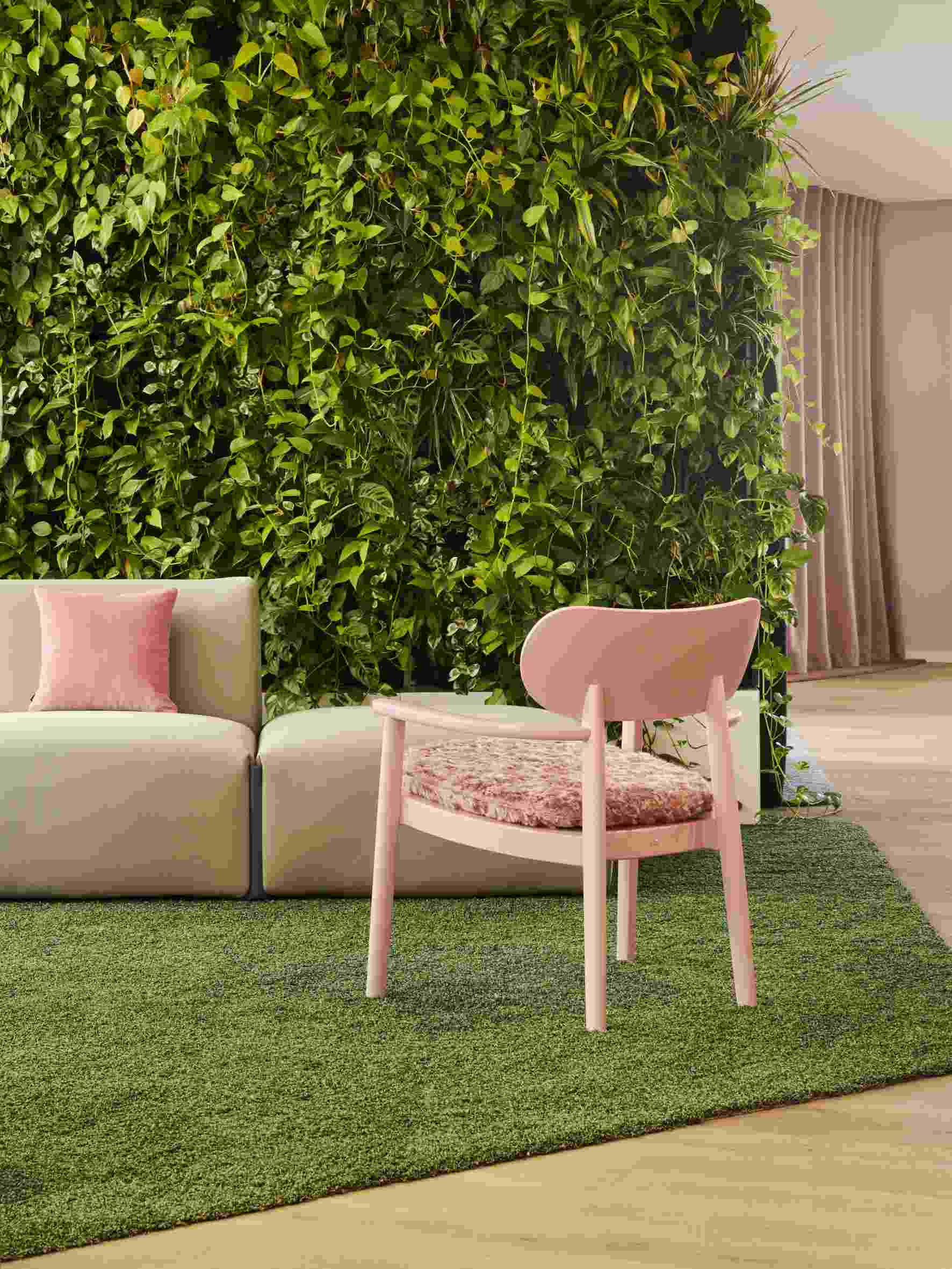 Rosa Loungesessel mit Armlehnen von Thonet, LIMITED EDITION, vor grüner Wand und Teppich.