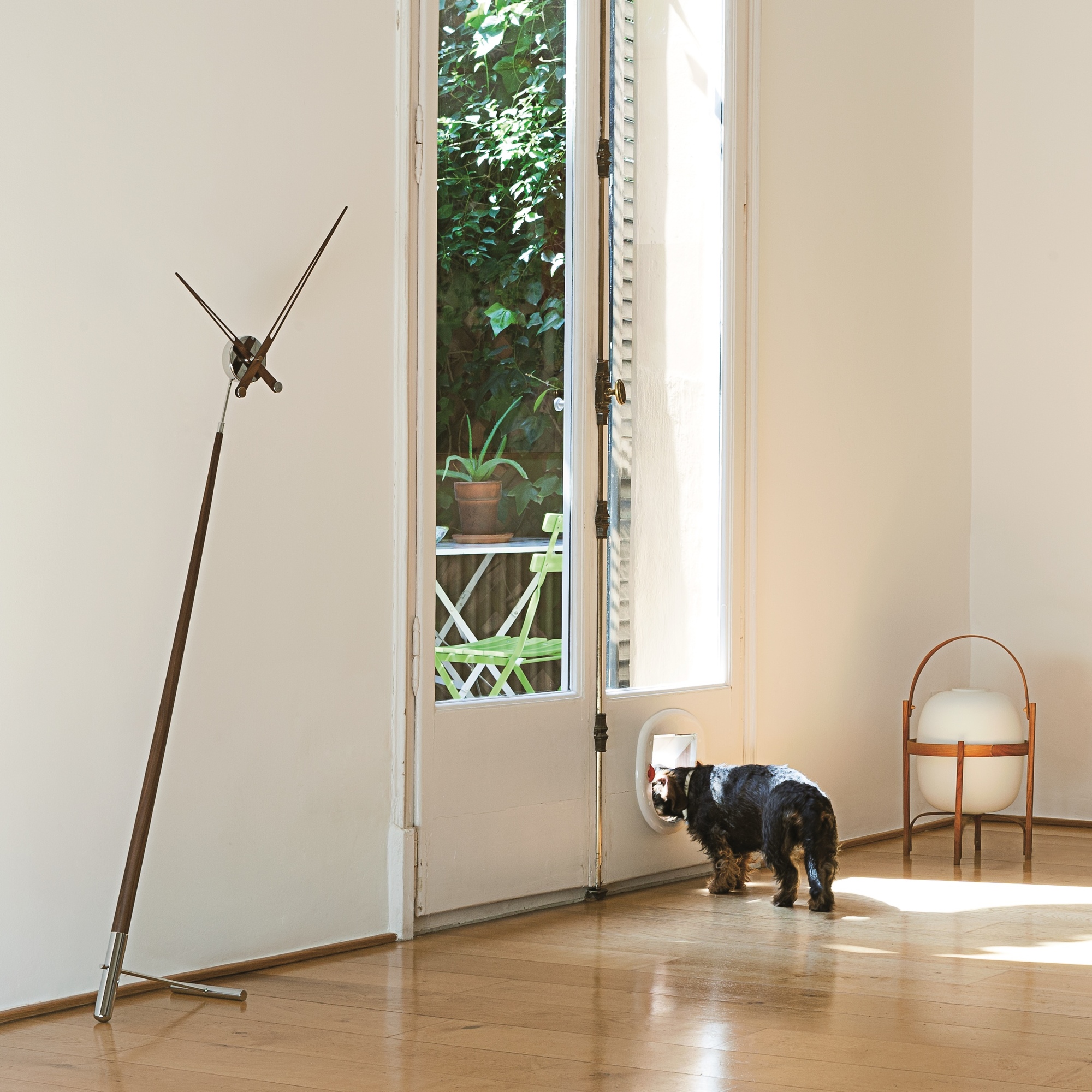 Elegante Pisa N Standuhr von Nomon im modernen Wohnzimmer mit Hund und Terrassentür.
