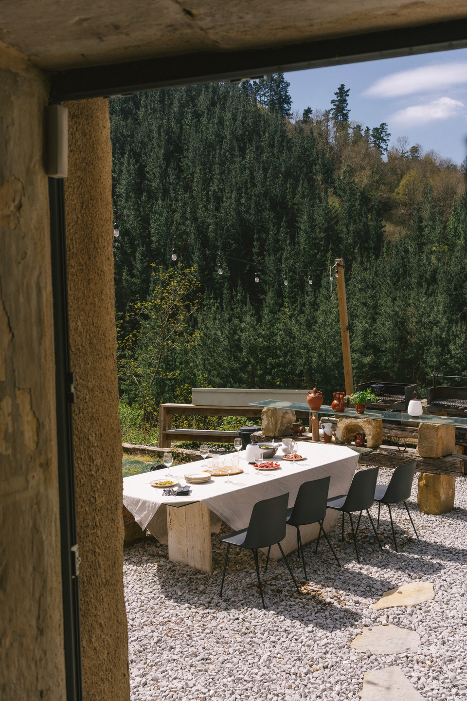 Esstisch im Freien mit vier Rely HW70 Stühlen von AndTradition auf Kiesboden.