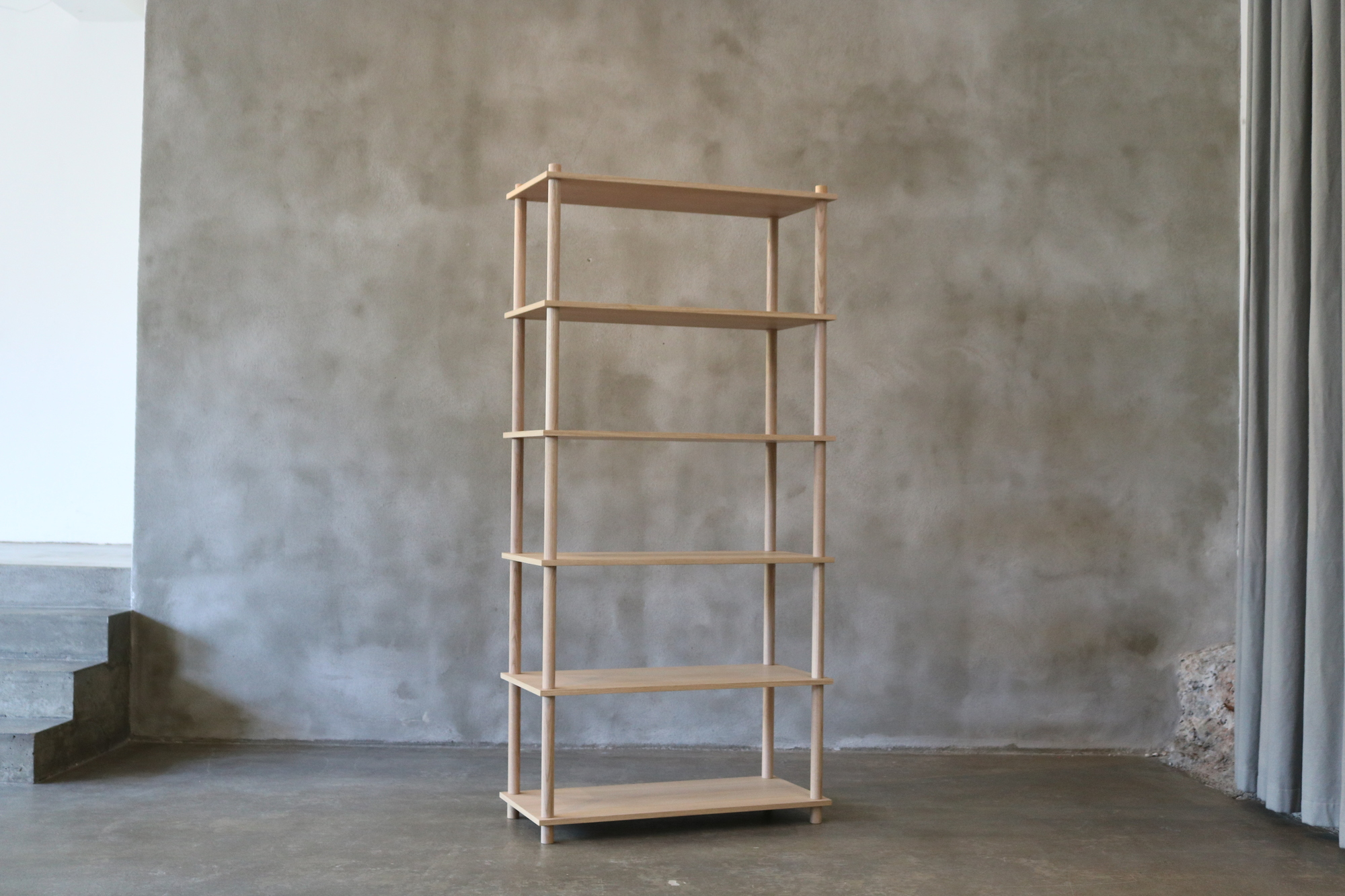 Elevate Regal: Freistehendes, helles Holzregal mit fünf Böden vor grauer Wand.