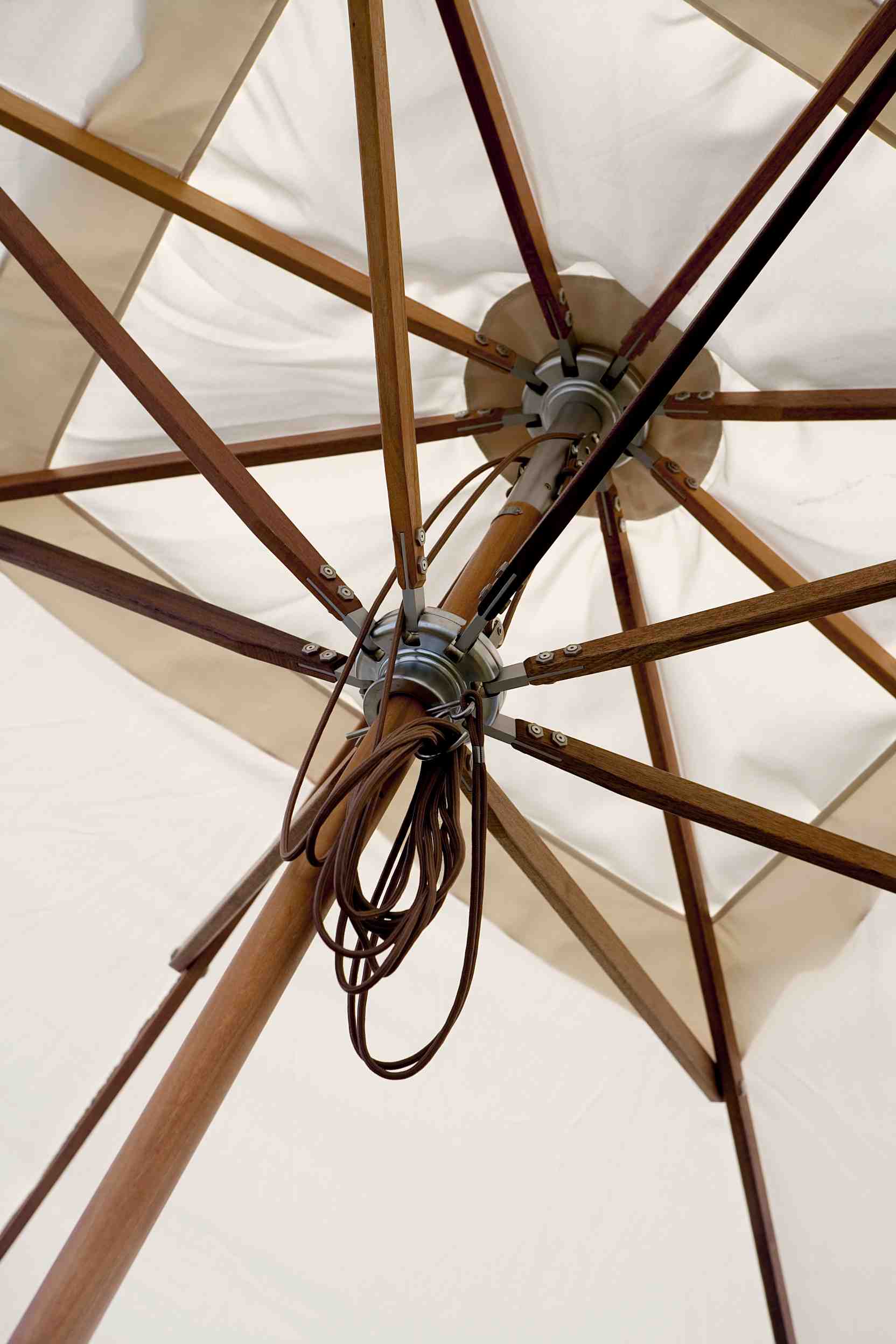 Detailaufnahme des Atlantis Sonnenschirms von Skagerak mit Holzgestell und beigem Schirmstoff.