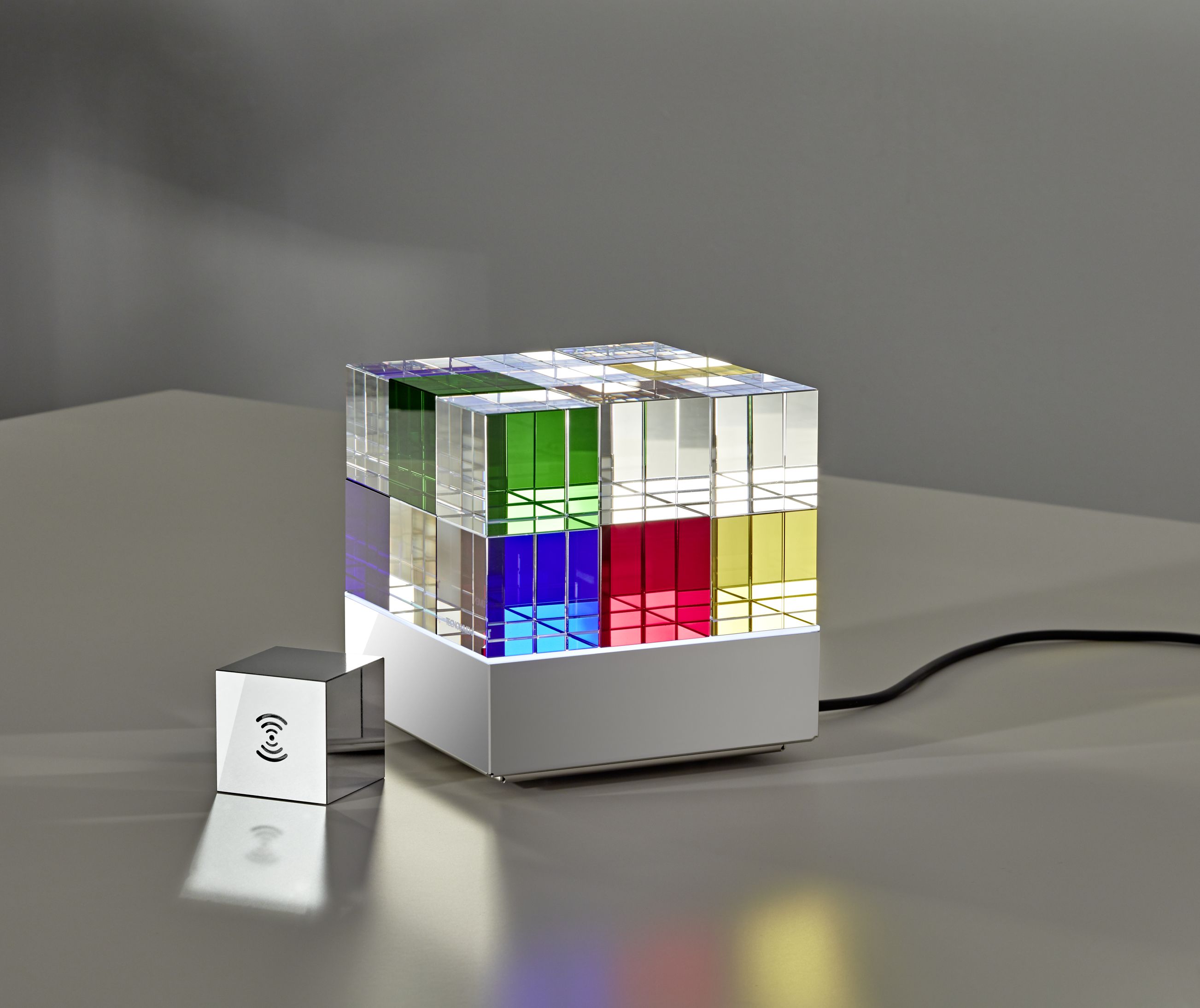 Cubelight move Lichtobjekt von Tecnolumen: Kubusförmige Tischleuchte mit farbigen Acrylglas-Elementen und Steuerung.