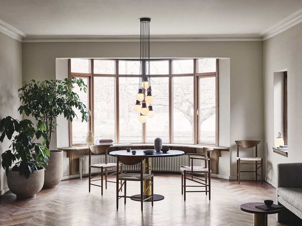 AndTradition Drawn HM4 Stuhl mit Armlehnen aus Holz und Rattan in stilvollem Interieur.