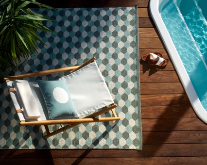 Outdoor Teppich mit geometrischem Muster, Liegestuhl und Pool für entspannte Stunden im Garten.