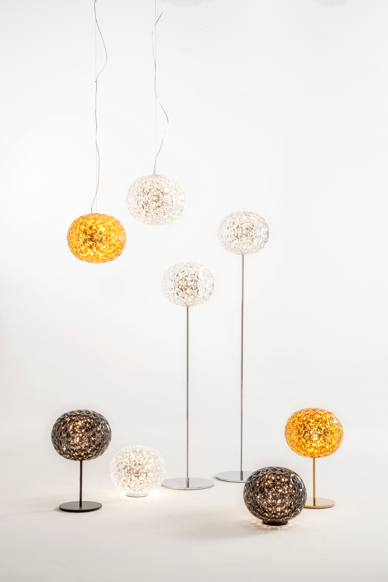 Produktfoto: Verschiedene Kartell Planet Leuchten, Tisch-, Steh- und Hängeleuchten in Rauch, Gold und Kristall.