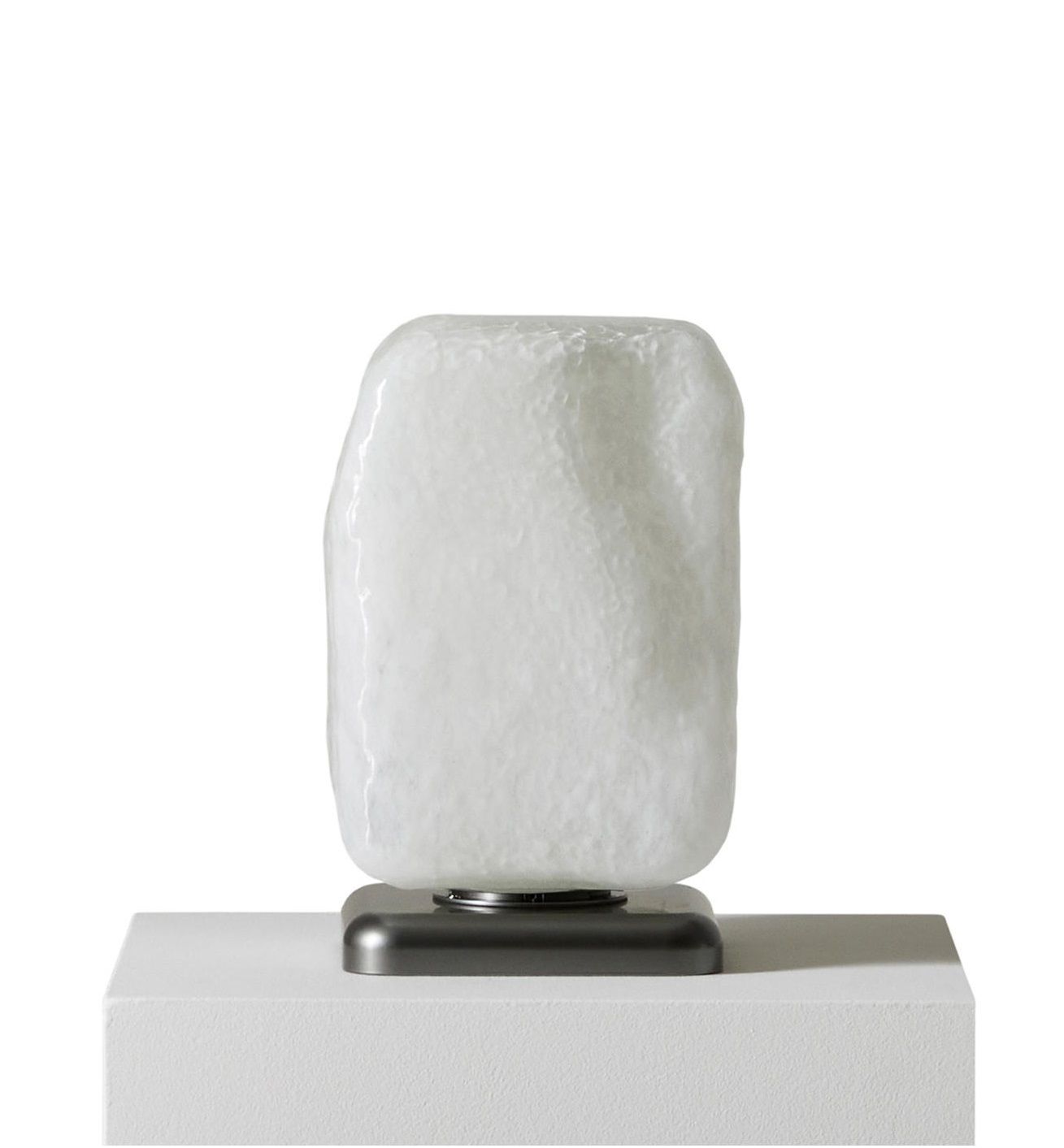 Nahaufnahme der Cassina Stone Light Tischleuchte mit weißem Glasschirm und dunklem Sockel.