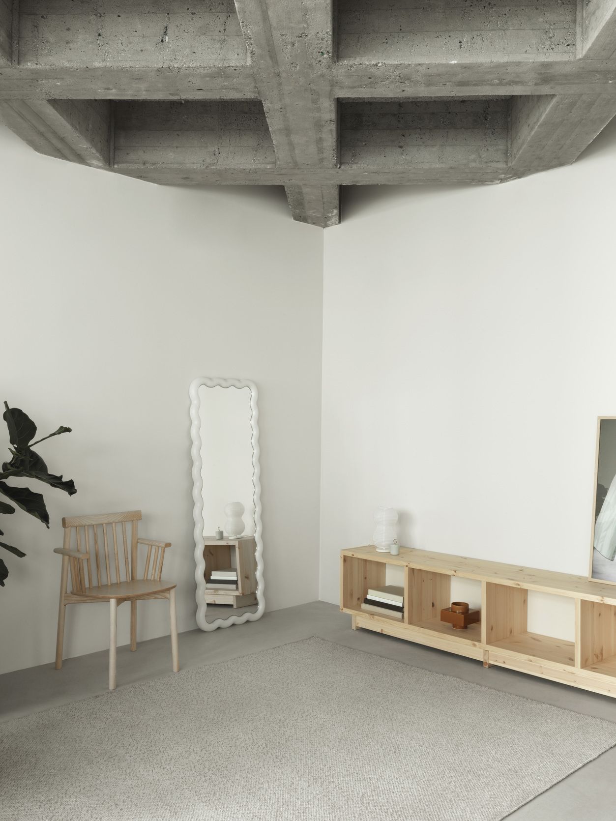 Heller Raum mit Normann Copenhagen Pind Armchair Holzstuhl, Spiegel und Holzregal.