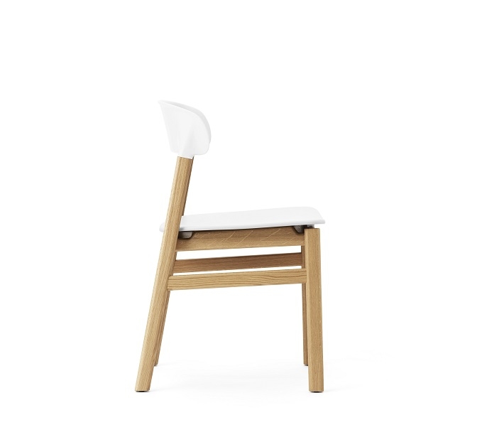 Herit Chair von Normann Copenhagen, Seitenansicht: Holzgestell mit weißer Sitzfläche und Rückenlehne. Design Stuhl.