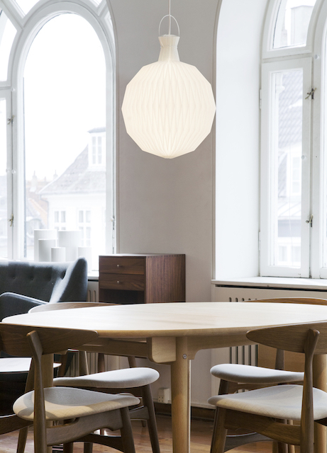 Le Klint Model 101 Pendelleuchte, Medium, mit weißem Papierschirm im Interieur über Esstisch.