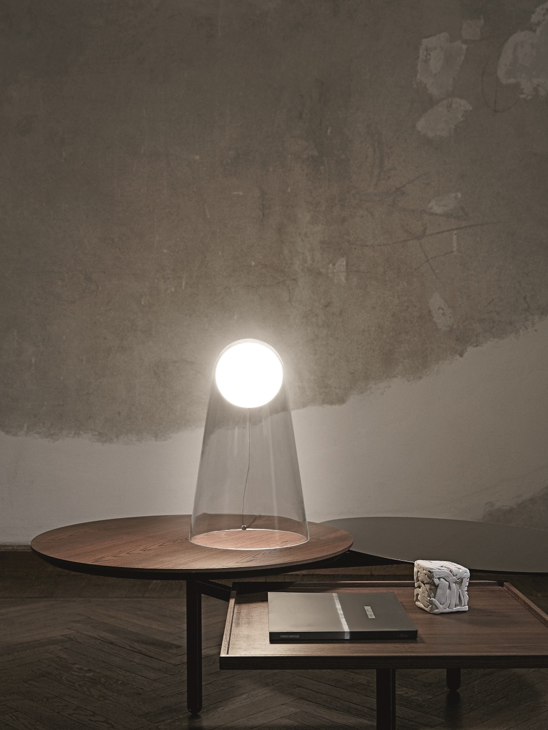 Satellight Tischleuchte von Foscarini: Moderne Lampe mit klarem Schirm auf einem Holztisch.