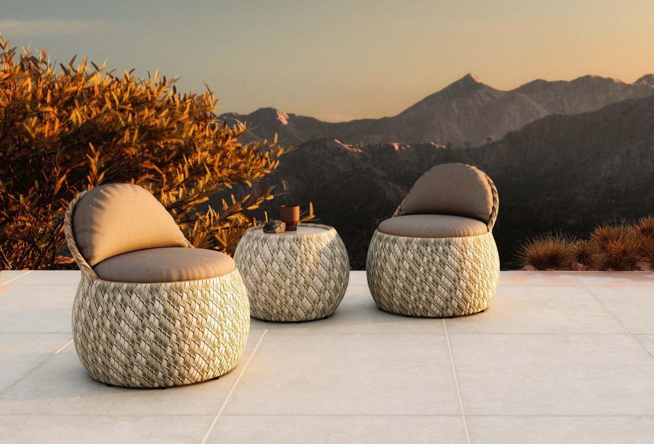 Zwei Korbsessel und ein Beistelltisch aus Korbgeflecht vor Bergkulisse für den Garten oder die Terrasse.