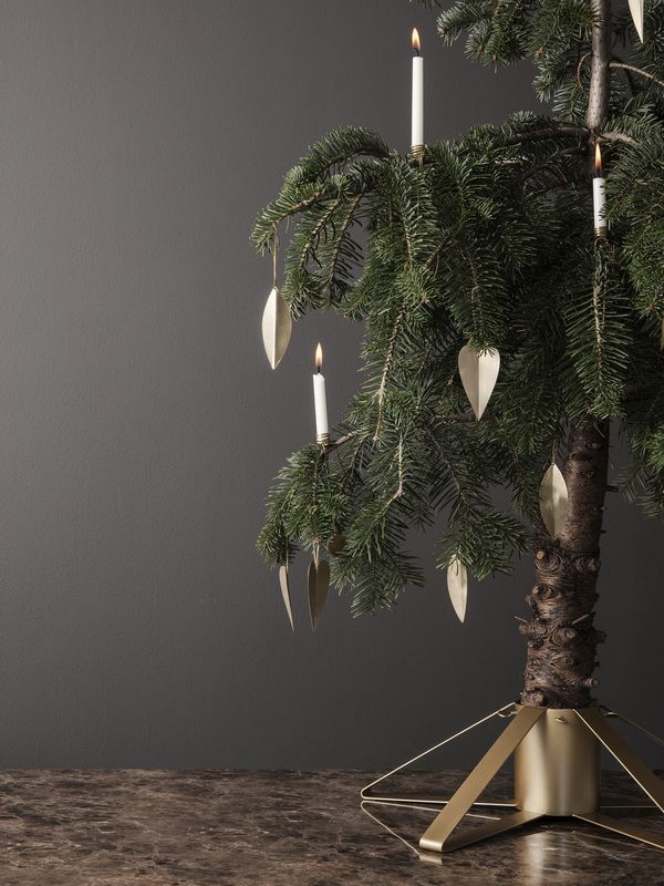 Detailaufnahme: Weihnachtsbaum im Messing Christbaumständer von Ferm Living mit Kerzen und Schmuck.