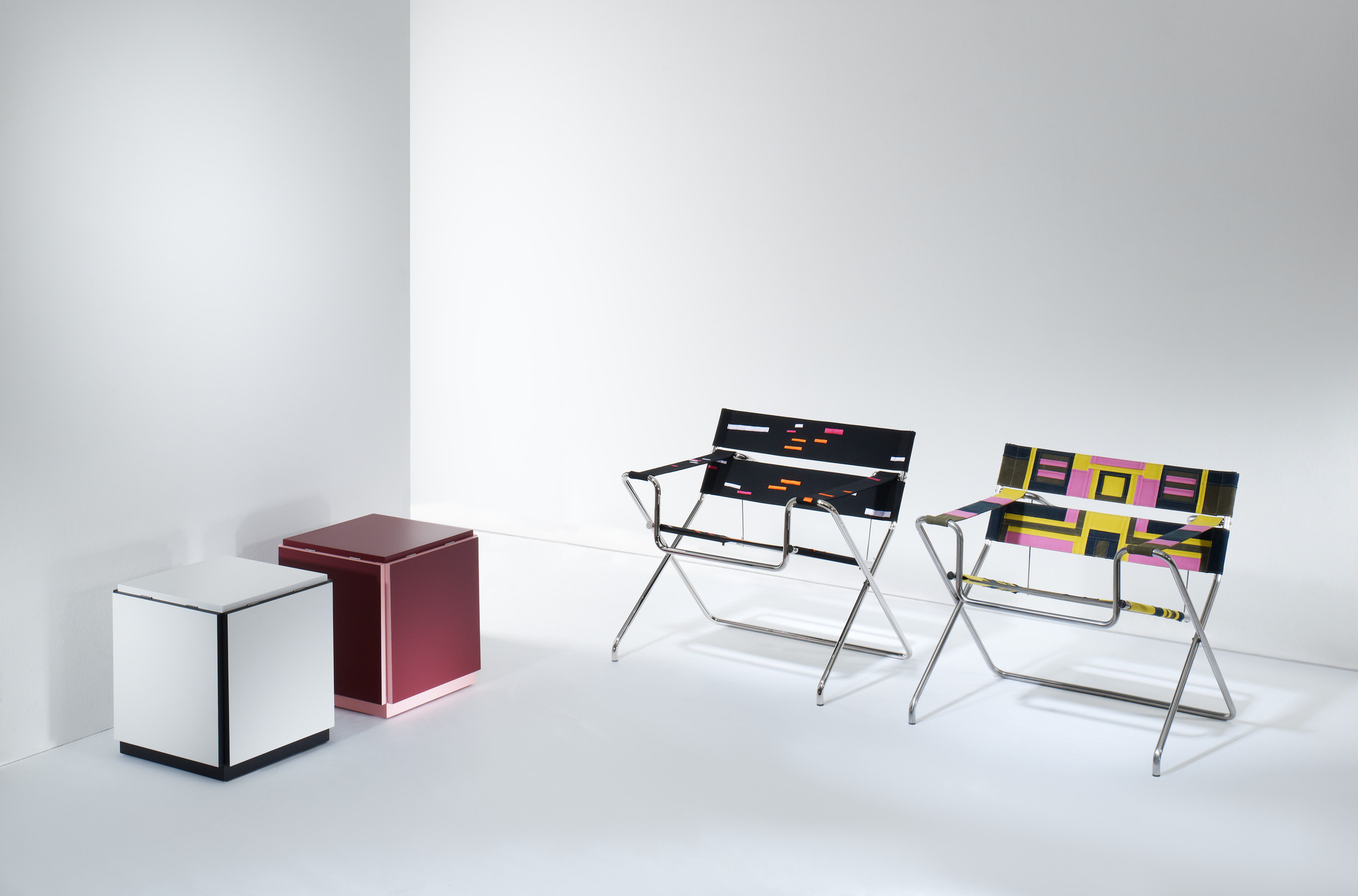 K10N Klapptisch und zwei Bauhausnowhaus Tecta V2 Klappstühle mit farbenfrohen Mustern.