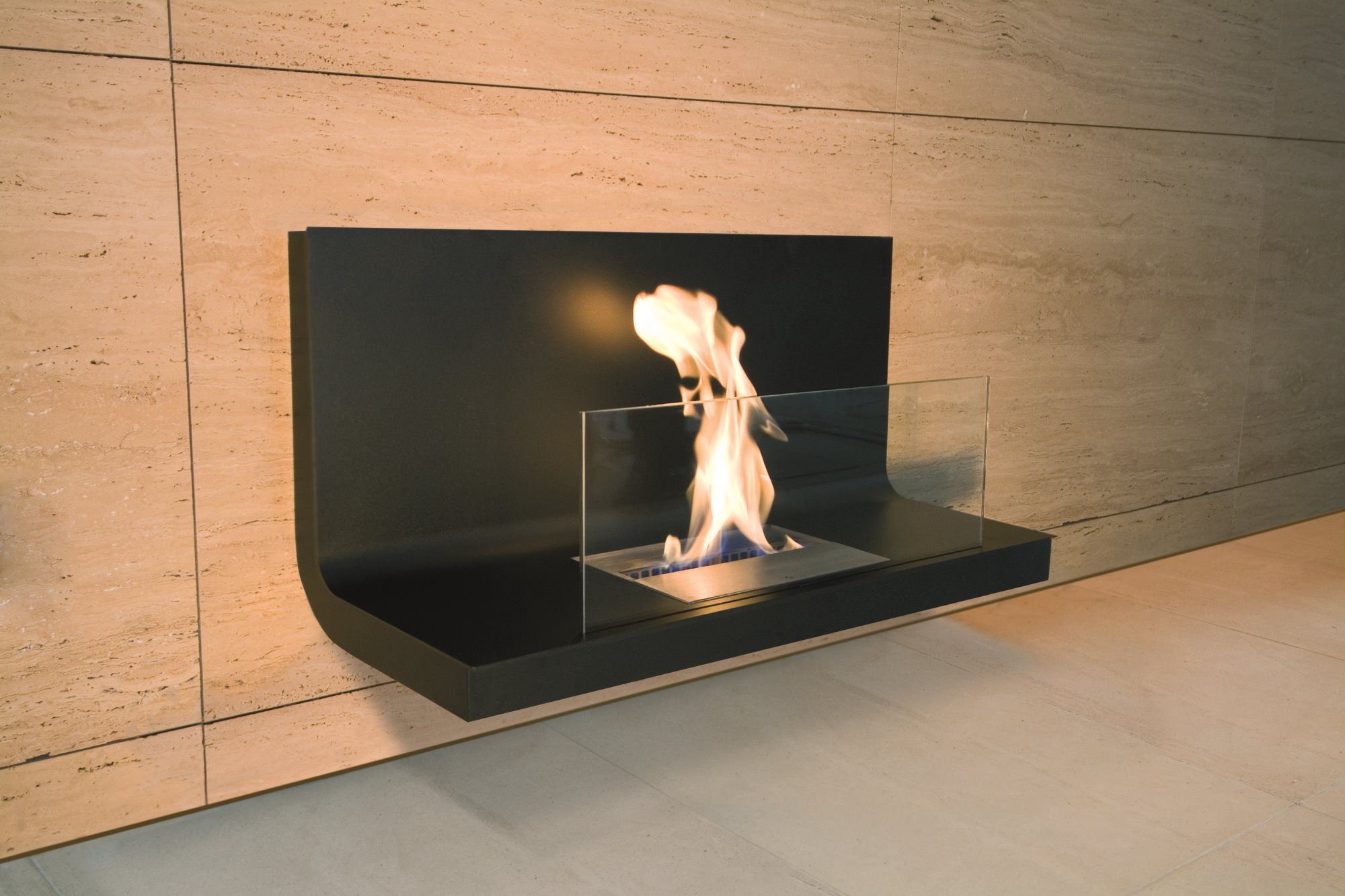 Wall Flame 1 Ethanol Kamin Radius an beiger Wand mit Glasumrandung und brennender Flamme.