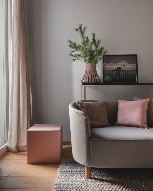 Hey Sign Quart Sitzmöbel: Rosa Filz Hocker als Beistelltisch neben grauem Sofa mit Kissen.