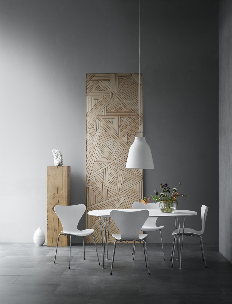 Esszimmer mit Caravaggio Pendelleuchte von Fritz Hansen über einem weißen Tisch und Stühlen.