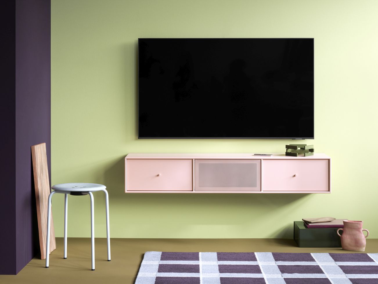 Octave V TV-Bank in Fennel mit schwarzem Gestell an grüner Wand. Moderne TV-Möbel für Wohnzimmer.