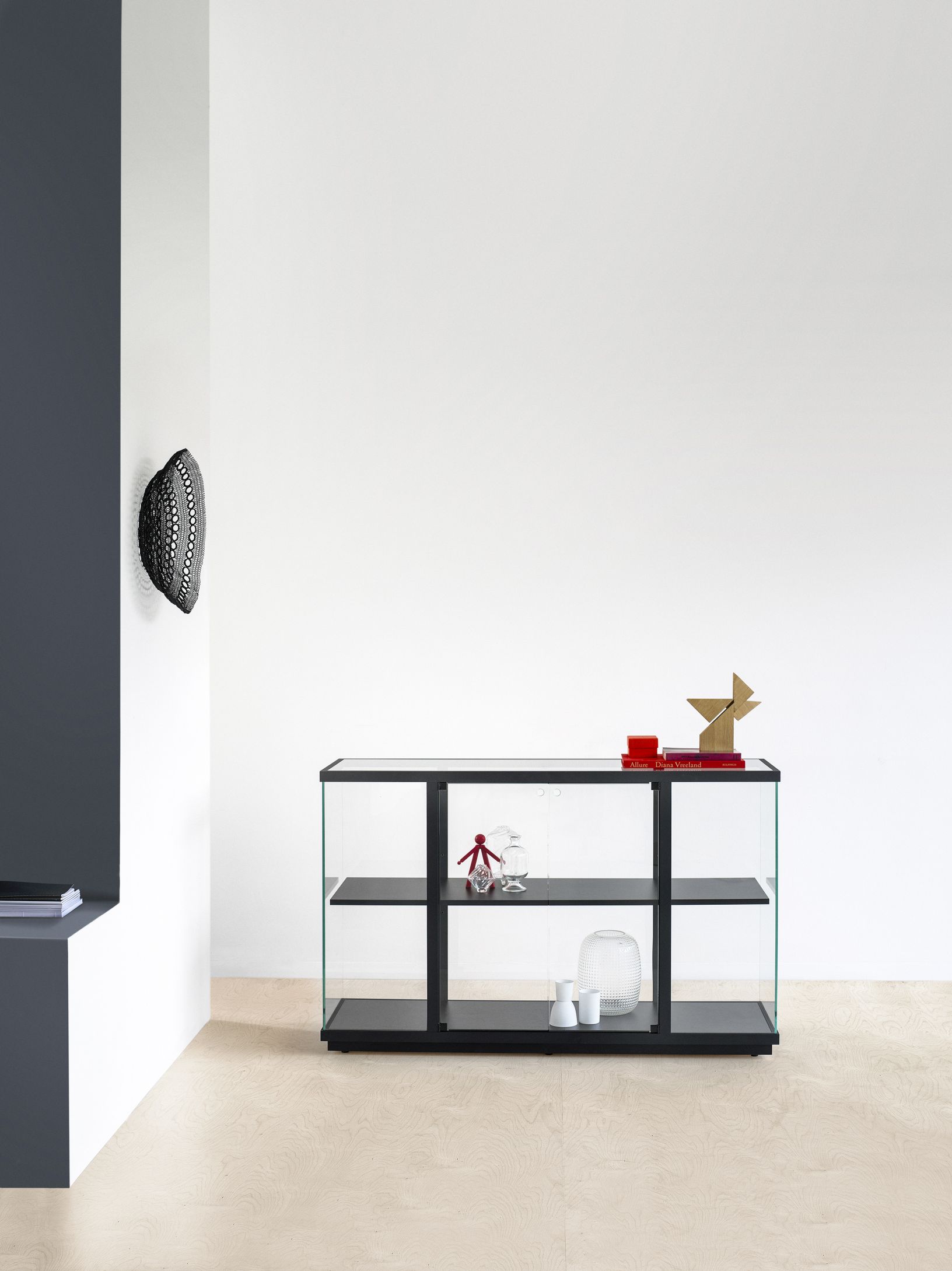 Schwarze Stolp Vitrine mit Glasseiten und drei Regalböden, ideal für Wohnzimmer oder Esszimmer.