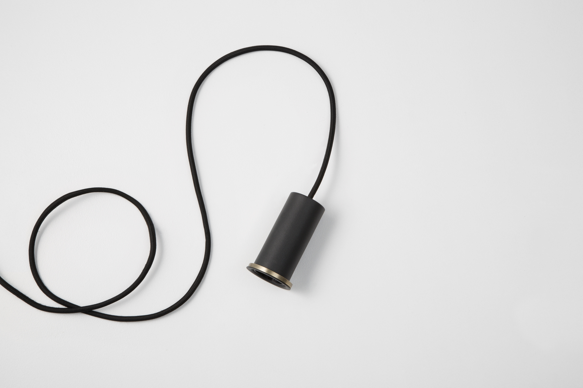 Schwarze Collect Pendelleuchte von Ferm Living mit Textilkabel auf weißem Hintergrund. Moderne Hängelampe.