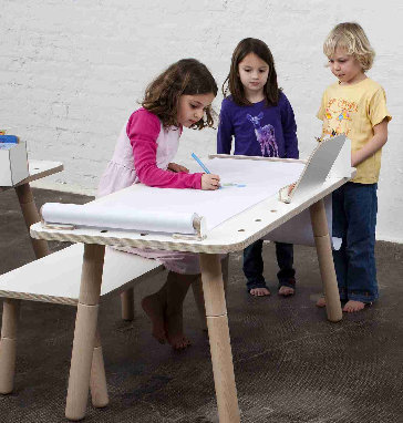 Kinder zeichnen am Kindertisch mit Papierrolle und Abreißschiene. Growing Table Zubehör für kreatives Spielen.