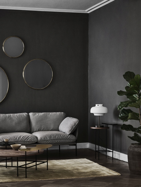 AndTradition Palette Table JH25 Couchtisch im Wohnzimmer mit Sofa, Lampe und runden Spiegeln.