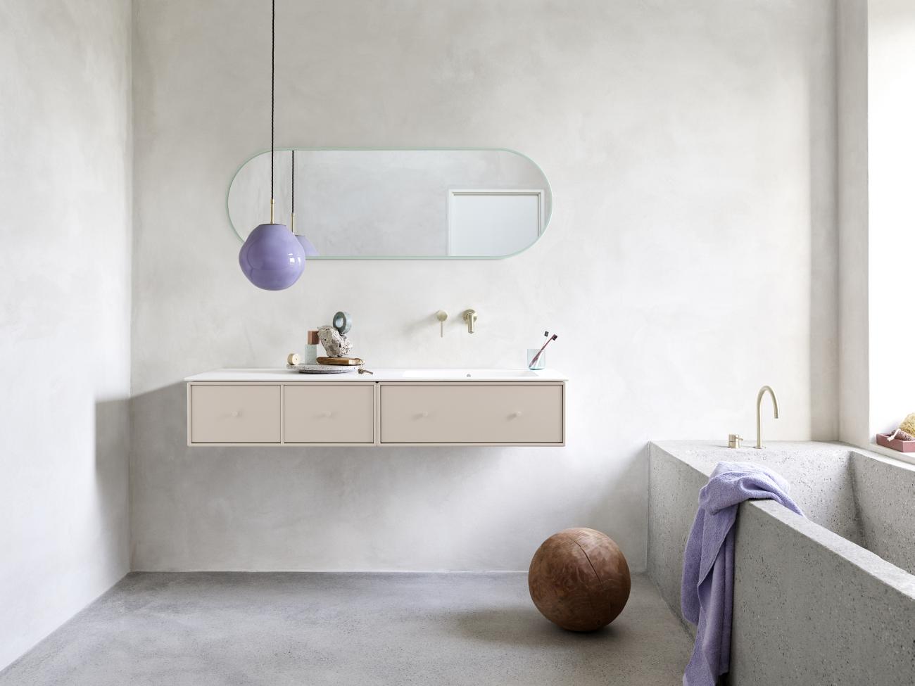 Badezimmer mit Montana Spiegel, Waschtisch, Badewanne und lila Lampe. Moderner Spiegel für stilvolles Badezimmerdesign.