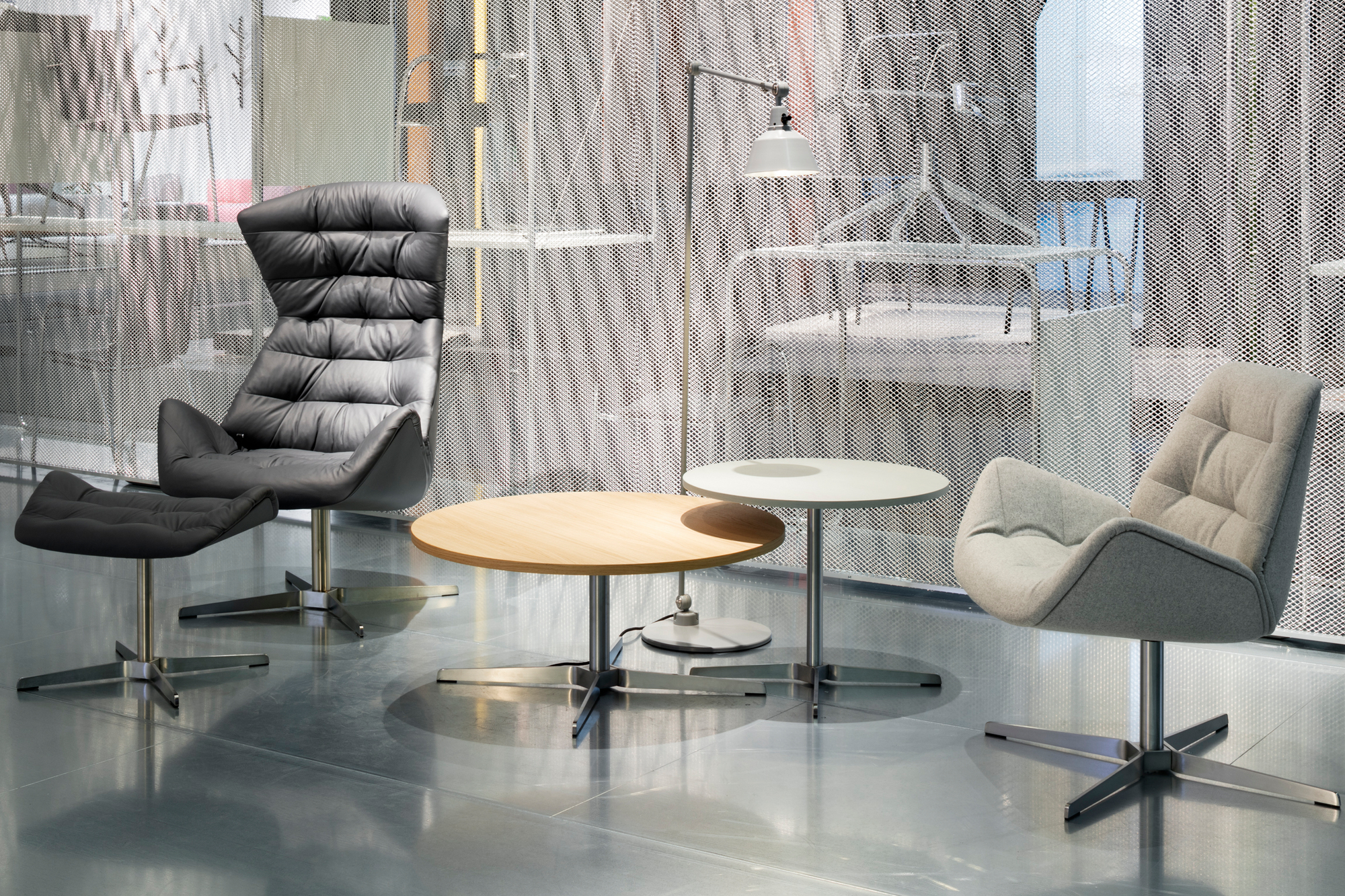 1808 Thonet Beistelltisch aus Holz mit Metallfuß neben Sesseln und Stehlampe.