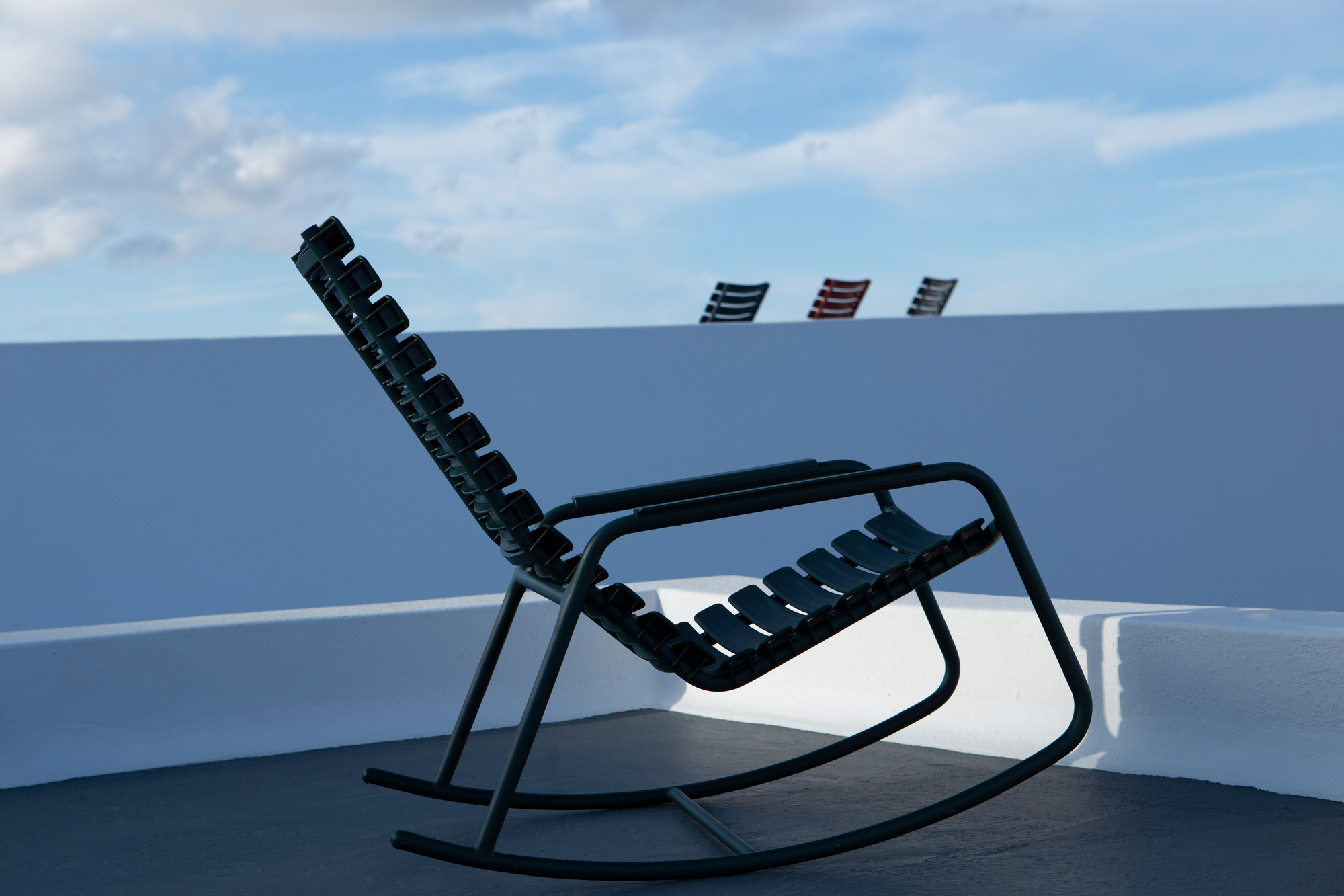 Houe ReClips Schaukelstuhl für den Außenbereich, modernes Design mit Kunststofflamellen und Metallgestell.