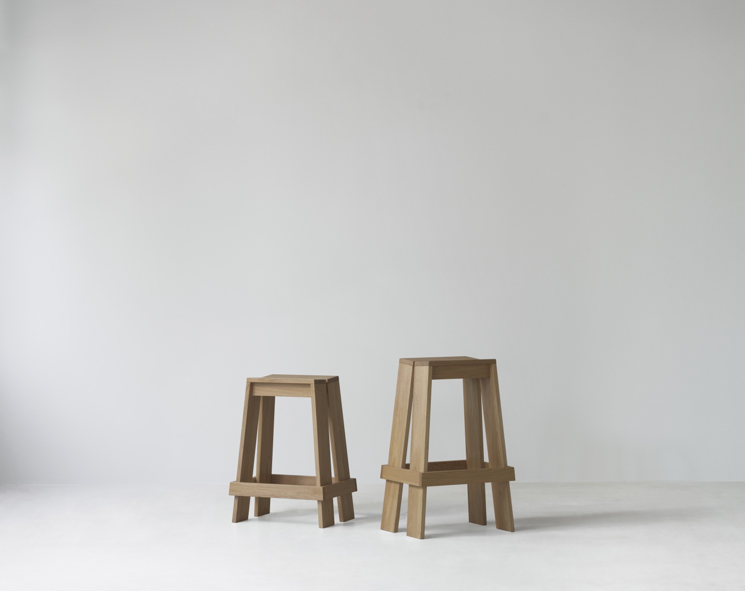 Zwei hölzerne Let Barstool Barhocker von Normann Copenhagen, Höhe 75 cm, auf weißem Hintergrund.
