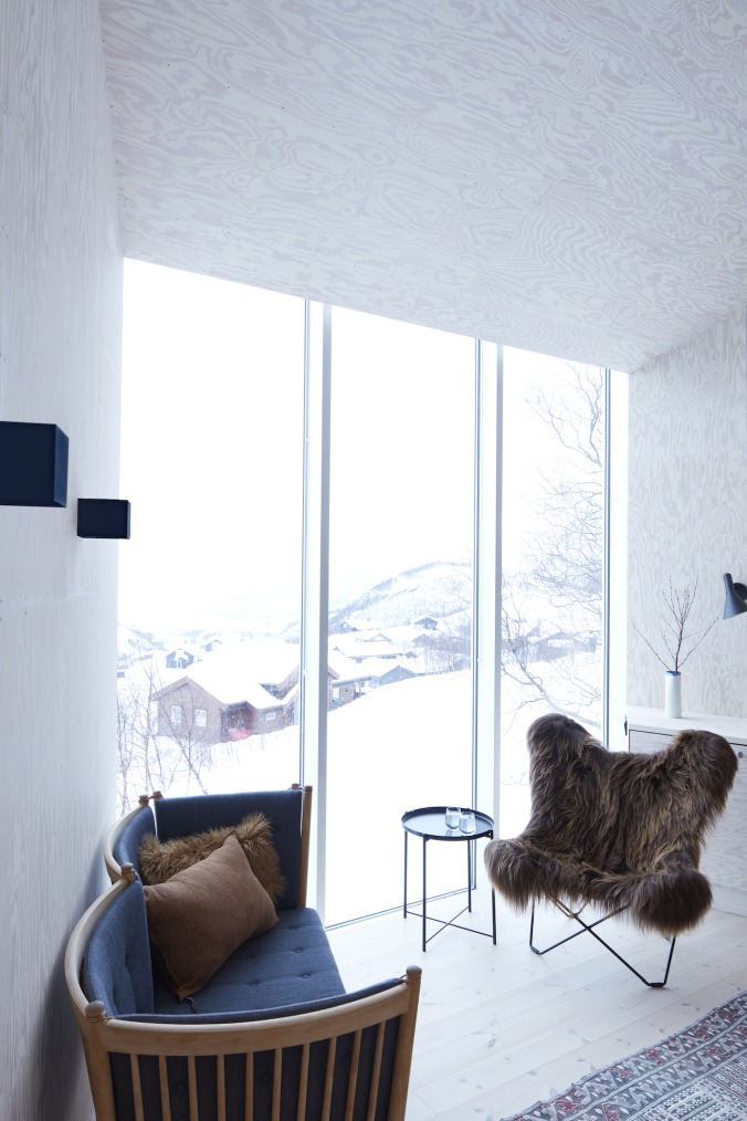 Iceland Mariposa Butterfly Chair Sessel mit Schaffellbezug in modernem Interieur mit Winterausblick.