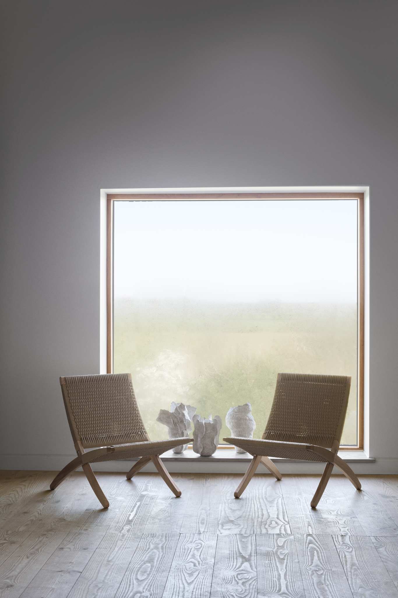 Zwei Cuba Sessel mit Papiergeflecht und geölter Eiche von Carl Hansen vor Fenster.