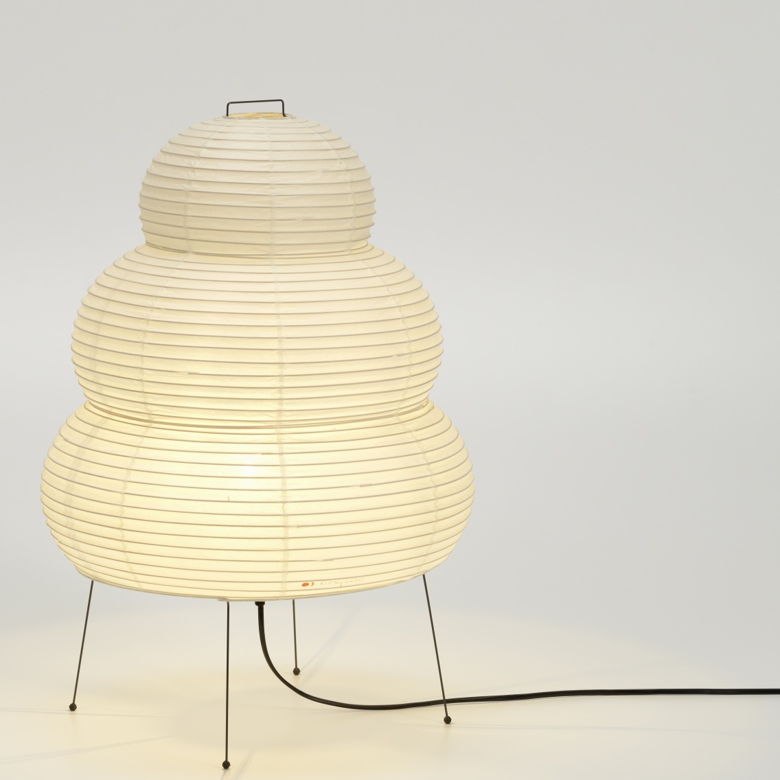 Akari Tischleuchte 24N von Vitra: Dreistufige Papierleuchte auf filigranem, schwarzem Drahtgestell.