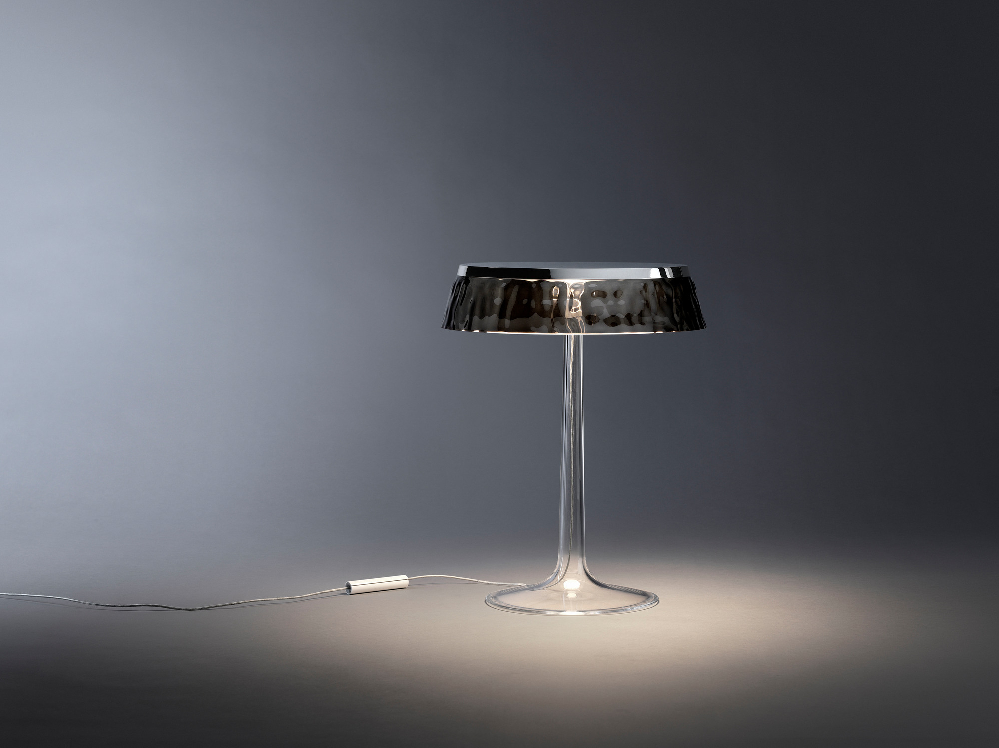Bon Jour Tischleuchte von Flos: Moderne Tischlampe mit transparentem Fuß und grauem Lampenschirm.