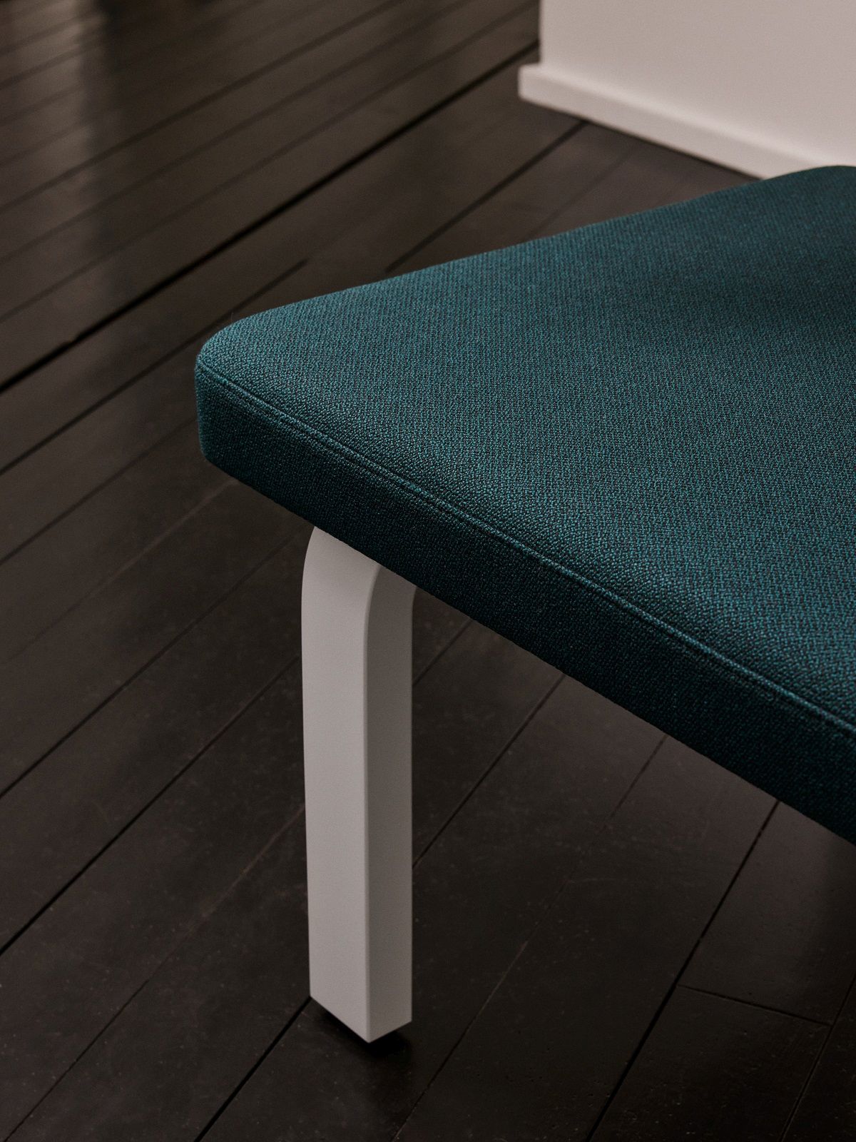 Detailaufnahme der Bench 167 Bank von Artek: Türkisfarbene Sitzfläche und weißes Bein. Design Sitzbank.